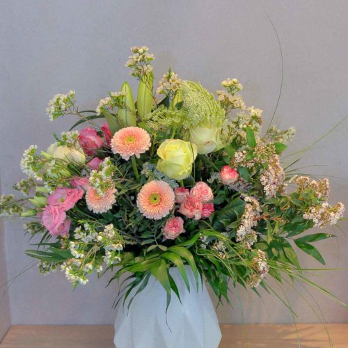 Bouquet rond de fleurs pastel dans un vase en céramique style Origami