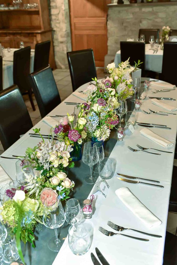 Centtre de table de plein de pot de confiture avec différantes variétées de fleurs de jardin